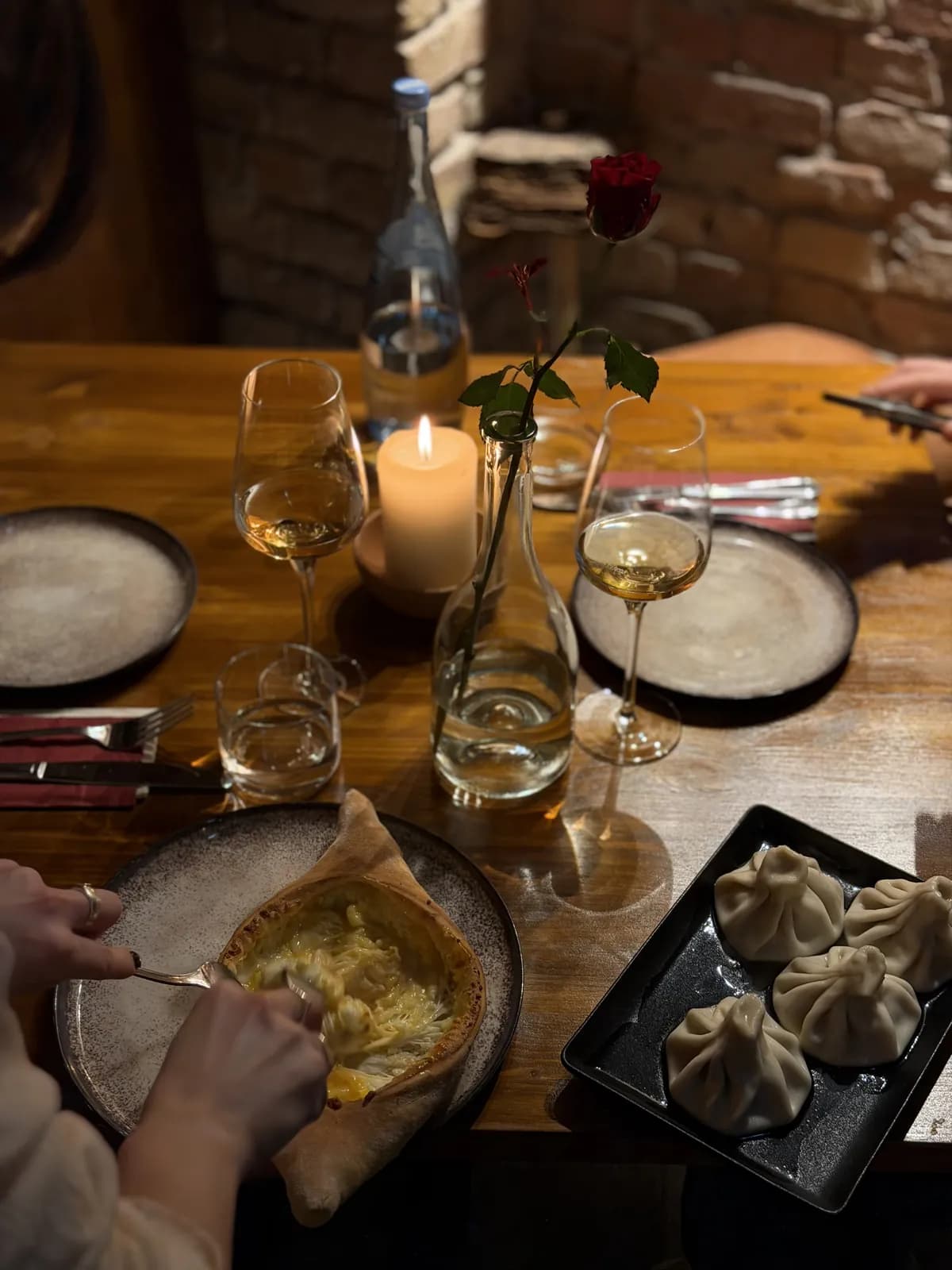 Adjaruli Khachapuri und Khinkali auf einem Tisch bei Kerzenlicht